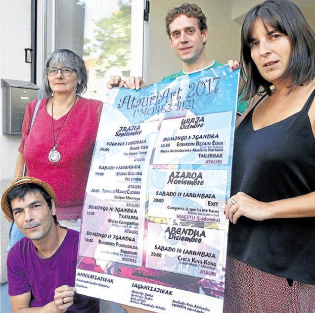 Los organizadores del festival sujetan el cartel con la programación de este año.
