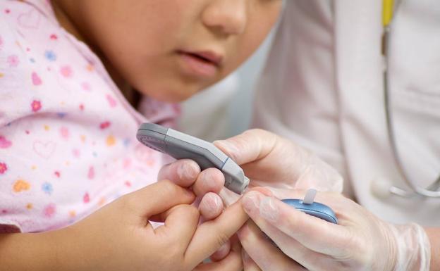 Un médico mide con un aparato la cantidad de azúcar en la sangre de un niño. /Anette Romanenko