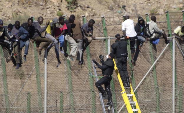 Inmigrantes intentan cruzar la valla de Melilla./Archivo