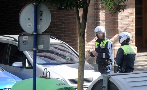 Dos agentes locales colocan una multa a un vehículo mal aparcado. /Iosu Onandia