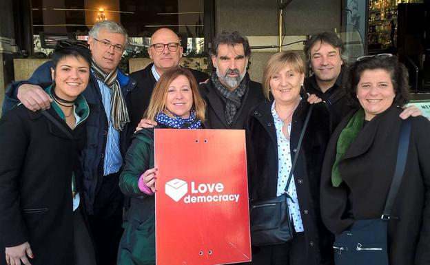 La alcaldesa de Calella, Montserrat Candini –en el centro sujetando el cartel–, junto al líder de Òmnium, Jordi Cuixart, en una imagen de archivo. /