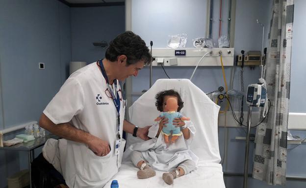 Javier Benito, con una niña ajena a la información, en Urgencias Pediátricas de Cruces./EL CORREO