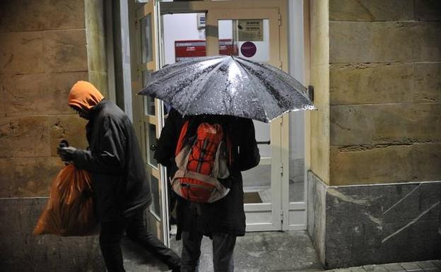 Dos personas a las puertas de un albergue este invierno. / I. PÉREZ