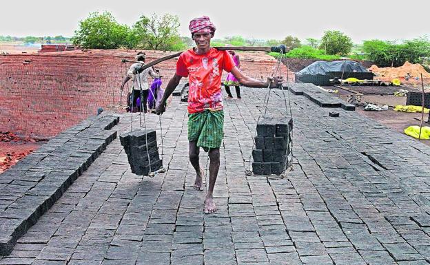 Un hombre traslada ladrillos en un horno de la India, el país donde más personas malviven en condiciones de servidumbre./Noah Seelam