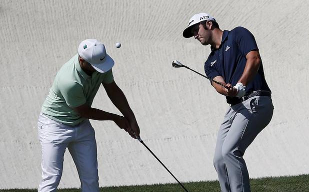 Jon Rahm golpea la bola junto al sueco Alex Noren durante el entrenamiento de ayer./EFE