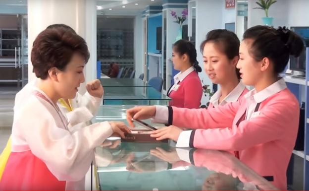 Unas mujeres norcoreanas compran un móvil en Pyongyang, /RR SS