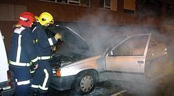 Bomberos sofocan un coche que ardió por un pertardo en Bilbao en la Nochevieja de 2004. / L. Calabor/