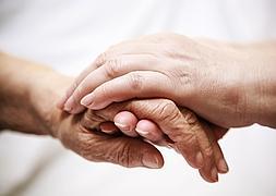 Un familiar coge la mano de un enfermo para reconfortarle./ Fotolia/