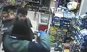Momento en que el atracador amenaza al cliente borracho con una pistola. /Youtube/