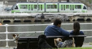 Una pareja contempla el paso del tranvía desde el muelle de Uribitarte. / F. GÓMEZ/