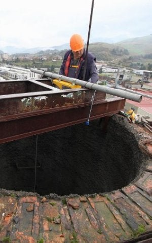 Un operario trabaja en la reforma de la chimenea. ::
JOSÉ MONTES/