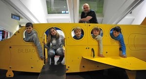 Kiko y Marian posan con los niños que han acogido en la zona de juegos del aeropuerto de Loiu. /I. Pérez/