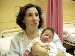 Marta López muestra a la pequeña Naiara. A la derecha, una auxiliar señala el lugar del parto./ Luis Calabor/