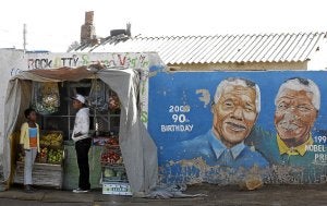 Venta de frutas junto a un muro con el rostro de Mandela. | REUTERS/