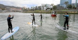 Los cuatro deportistas acompañan a la lancha de los Bomberos tras el rescate. /Luis Calabor/