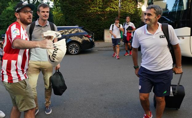 Vlverde sonríe a un aficionado en presencia del presidente del Athletic a su llegada a Alemania. 