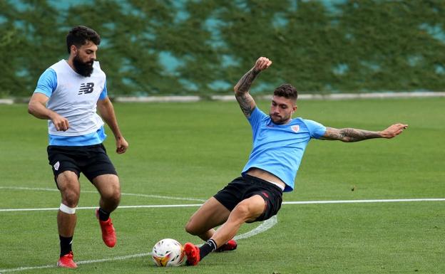 Unai Nuñez corta un balón durante un entrenamiento en presencia de Asier Villalibre. 