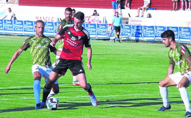 Raúl García, el hasta ahora goleador rojillo, pugna por un balón con César Caneda durante el primer amistoso del periodo estival frente a la SD Logroñés. /cdm