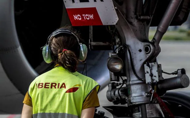 Una trabajadora de Iberia, junto a un aviÃ³n de la compaÃ±Ã­a./IÃ‘AKI ANDRÃ‰S