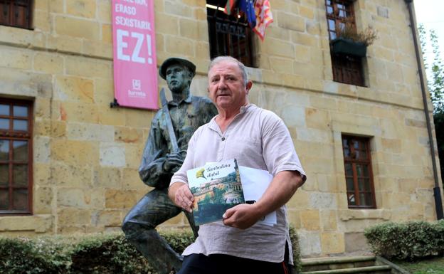 Joseba Agirre muestra su libro junto a la escultura al dantzari.