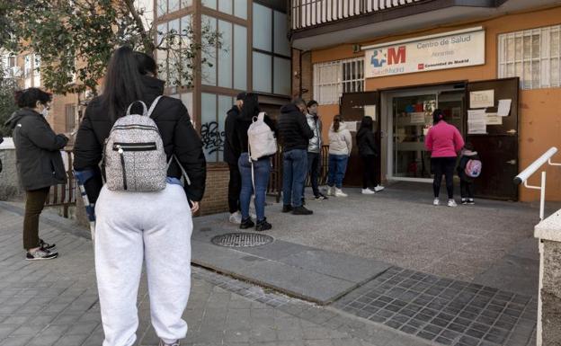 A group of people queue at the Madrid health center.