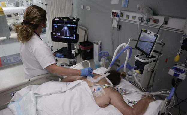A patient with covid is treated in the ICU, where she has been placed in a prone position. 