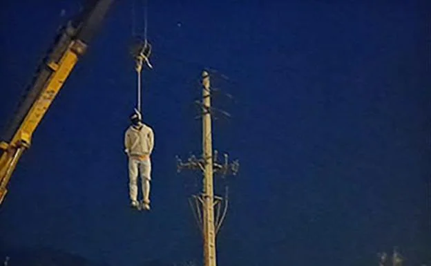 The body of Majid Reza Rahnavard hangs from a crane after his execution in the Iranian city of Mashad